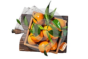 Organic Tangerines, mandarins with green leaves in wooden box. Isolated on white background.