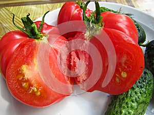 Organic tomato cut in half on a plate. Closeup.