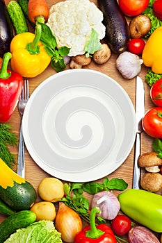 Organic Vegetables Around White Plate with Knife and Fork