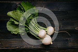 Organic vegetables. Fresh harvested turnip on the dark wooden background, top view