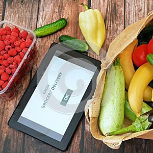 Organic Vegetables and fruits in cotton bag and tablet pc, online market, green grocery delivery at home concept, buy online