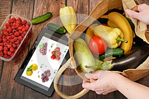 Organic Vegetables and fruits in wooden box and tablet pc, online market, green grocery delivery at home concept, buy online