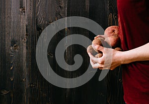 Organic vegetables. Hands holding fresh potatoes. Black wooden background with copy space