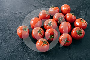 Organic vegetables and healthy eating concept. Harvested red tomatoes with water drops, black background. Close up texture. Open