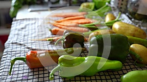 Organic vegetebles on a table: zucchini, beets, peppers, potatoes, carrots etc. Man lays out vegetables on a towel to