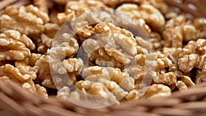 Organic walnut kernels nuts in rustic rattan wicker bowl.