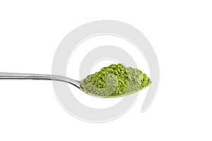 Organic wheatgrass or barley grass powder in steel tea spoon isolated on white. Detox superfood measuring