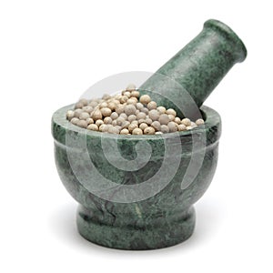 Organic White Pepper (Piper nigrum) on marble pestle.