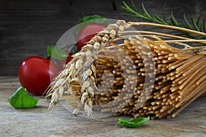 Organic wholemeal spaghetti with wheat ears, tomatoes and basil