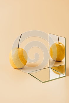 organic yellow pear reflecting in two mirrors