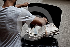 Organisation is key. Shot of a young man putting newspaper in the bin to be recycled.