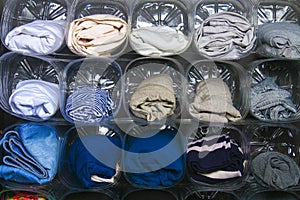 The organization of storage of clothes in the closet on the shelf. Secondary use of plastic bottles. Saving space. Convenient use.