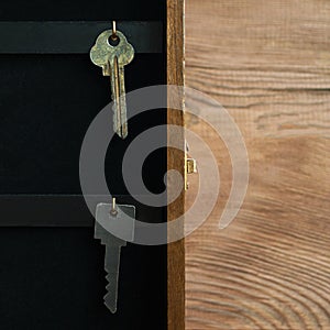 Organize your life, insurance and security concept: vintage opened wooden key holder box cabinet with keys hanging on golden hooks