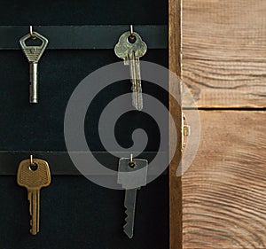 Organize your life, insurance and security concept: vintage opened wooden key holder box cabinet with keys hanging on golden hooks