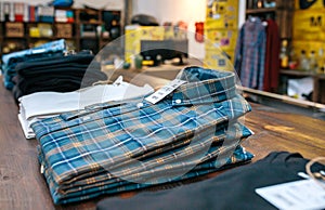 Organized blue plaid shirt stack over counter on vintage clothes shop