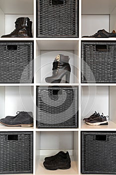 Organized shoe rack in modern interior, various footwear on wooden shelf, storage for shoes in a modern home