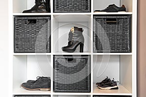 Organized shoe rack in modern interior, various footwear on wooden shelf, storage for shoes in a modern home