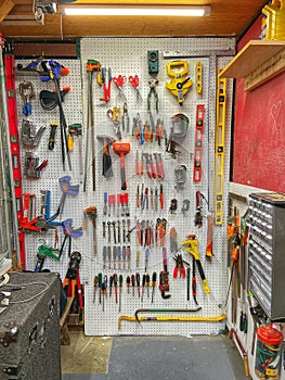 Organized shop storage featuring a pegboard wall of hanging variety of hand tools.