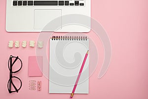 Organized stationery objects in shades of pink