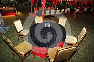 Organized tables and chair ready for guests on a grassland, decorated arrangement for an outdoor event or ceremony