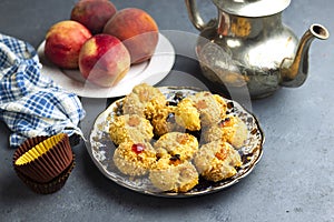 Oriental Algerian sweet cookies mchawak named in arabic , silver teapot and fresh peach fruit