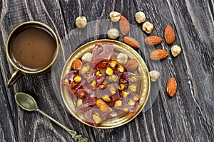 Oriental Arabian sweets with different nuts a cup of coffee. Eastern sweets. Traditional Turkish delight Rahat lokum on a wooden