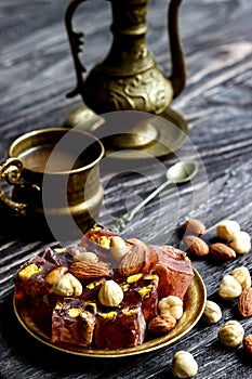 Oriental Arabian sweets with different nuts a cup of coffee. Eastern sweets. Traditional Turkish delight Rahat lokum on a wooden