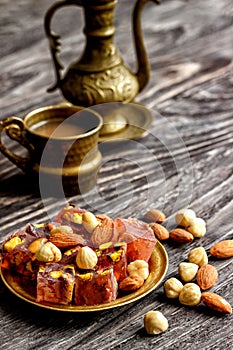 Oriental Arabian sweets with different nuts a cup of coffee. Eastern sweets. Traditional Turkish delight Rahat lokum on a wooden