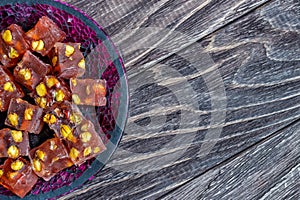 Oriental Arabian sweets with different nuts. Eastern sweets. Traditional Turkish delight Rahat lokum on a wooden background.