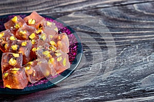 Oriental Arabian sweets with different nuts. Eastern sweets. Traditional Turkish delight Rahat lokum on a wooden background.