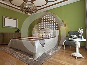 Oriental bedroom in Arab style, with a wooden headboard and green walls. TV unit, dressing table, armchair with coffee table