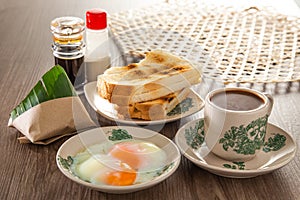 Oriental breakfast set in Malaysia consisting of coffee, nasi lemak, toast bread and half-boiled egg