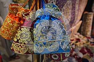 Oriental decorative embroidery canvas bags on eastern souk. Colorful textile handmade handbags hanging in souvenir shop