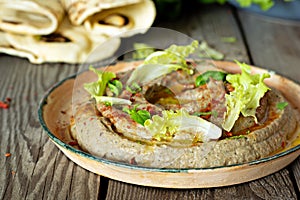 An oriental dish of baked eggplant babaganush eggplant puree with spices, herbs, lettuce and oriental flatbreads