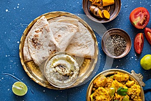 Oriental food Indian paneer sabji with chapati and chutney sous. indian cuisine. Indian Curry in copper brass with ingredients in