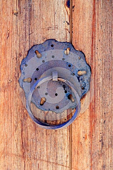 Oriental knocker on the weathered wooden door photo