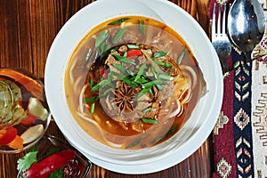 Oriental Lagman Uzbek soup on a wooden table.