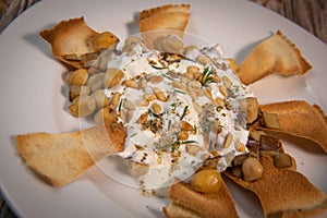 Oriental recipe aubergine and chickpea fatteh, pita, Greek yogurt, roasted pine nuts, zaatar