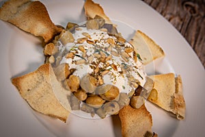 Oriental recipe aubergine and chickpea fatteh, pita, Greek yogurt, roasted pine nuts, zaatar