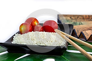 Oriental set of rice, tomatoes, chopsticks, green leaf and trans