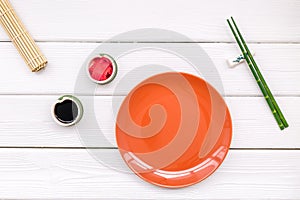 Oriental table set up with plate and bamboo sticks for sushi and maki on white background top view space for text