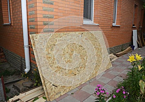 Oriented strand board OSB near brick house wall photo