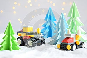 Origami 3D Xmas tree from paper on white background, bokeh lights and toy car. Merry Christmas and New Year card. Paper art style.