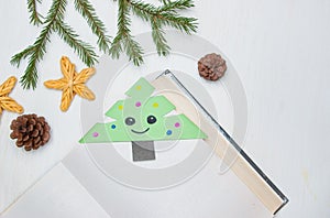 Origami bookmark in the form of a Christmas tree on a light background. Step 9. Instructions for creating bookmarks for a book in