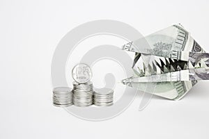 An origami figure of dollars in the form of an animal`s head with teeth and a ruble coin. The concept of the growth of the dollar