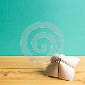 Origami fortune teller on wooden table with green copy space