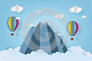 Origami made colorful hot air balloon flying over the mountain with cloud.Paper art style.