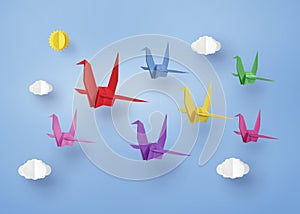 Origami made colorful paper bird flying on blue sky with clound