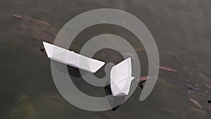 Origami paper boat swimming water in calm lake. Drifts creative ship journey.