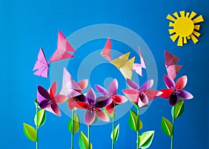 Origami paper flowers, butterflies, clouds and sun.